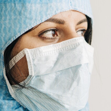 Doctor wearing protective workwear looking away